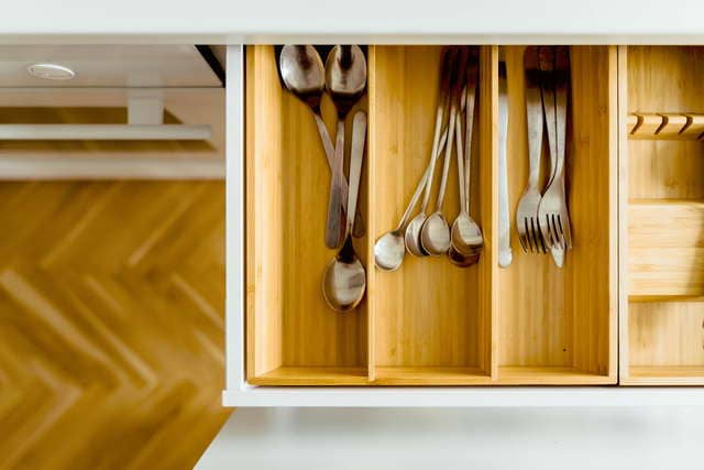 вилки, ложки и ножи в ящике кухонного стола